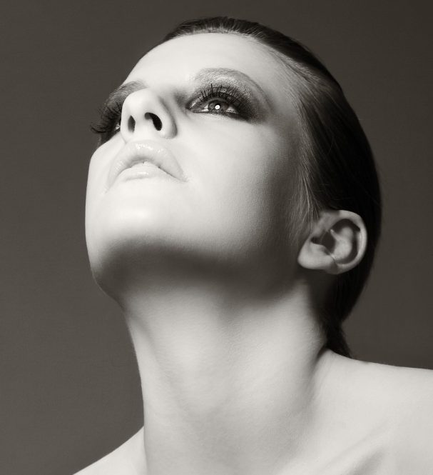 Skulpting Make-up Porträt einer Frau mit hochgezogener Kopfhaltung und dramatischem Make-up.